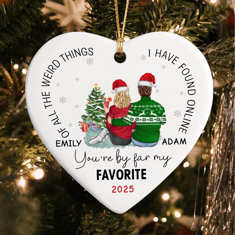A white heart-shaped ceramic ornament with a gold string.