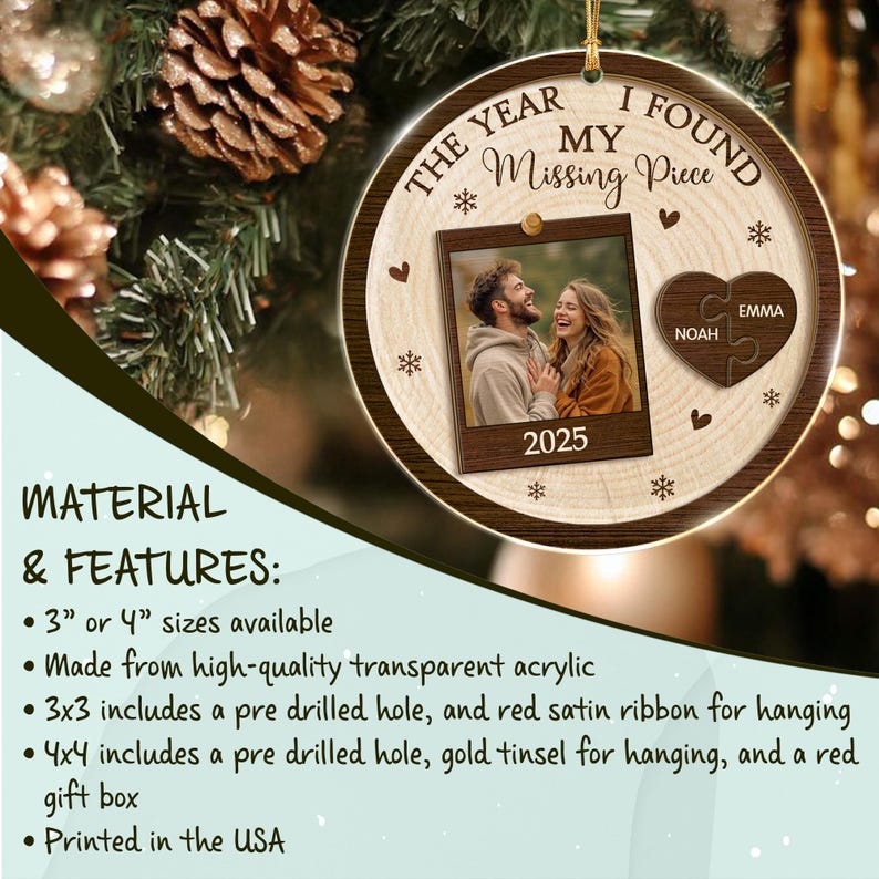 A round, wood-grain patterned acrylic ornament featuring the text THE YEAR I FOUND MY Missing Piece and 2025. It includes a central square photo frame showing a couple and a heart-shaped puzzle piece with the names Noah and Emma.