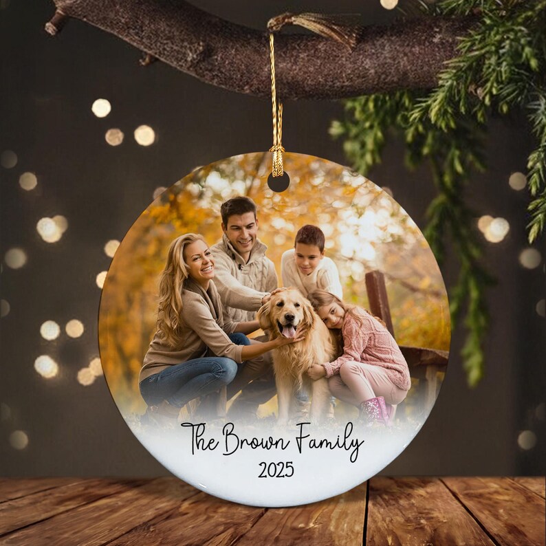 A round ceramic ornament featuring a printed photograph of a family with a golden retriever dog in an autumn setting.