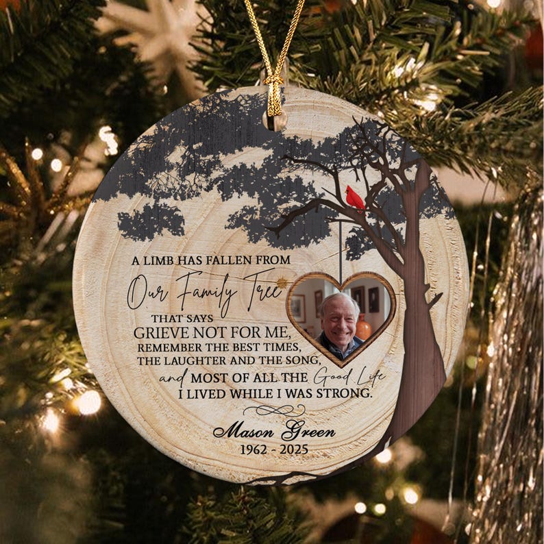 A round, wood-slice style memorial ornament featuring a printed tree silhouette, a red cardinal, and a heart-shaped photo frame.