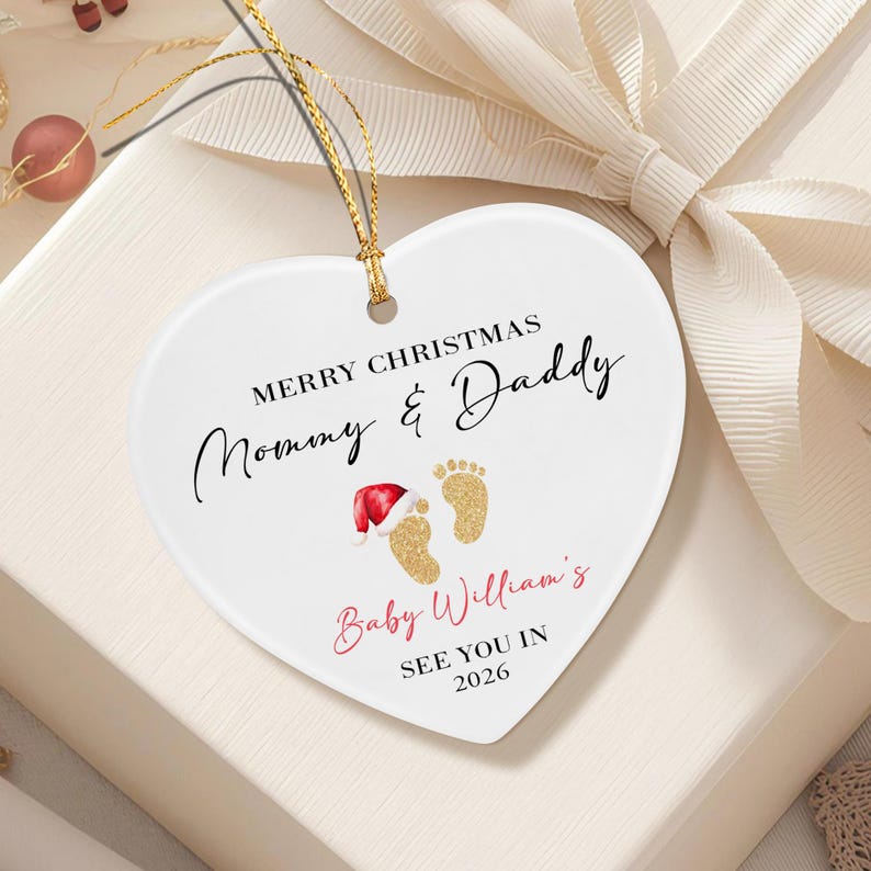 A white heart-shaped ceramic ornament with a gold string.