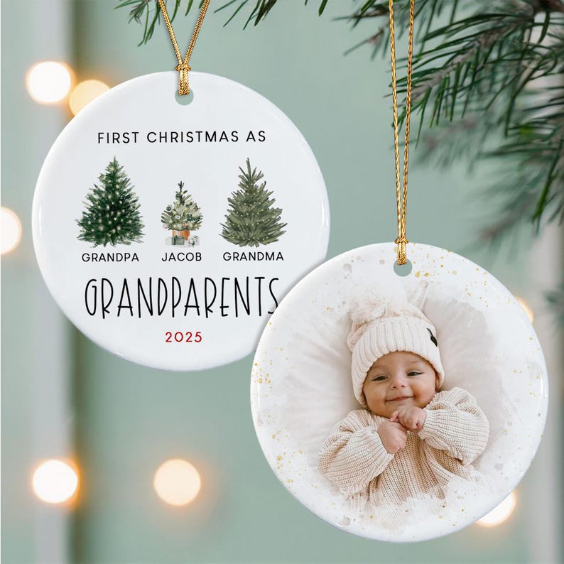 Two round white ceramic ornaments with gold hanging strings. One features three watercolor evergreen trees with the text FIRST CHRISTMAS AS GRANDPARENTS, names Jacob, and the year 2025. The other displays a photograph of a baby.