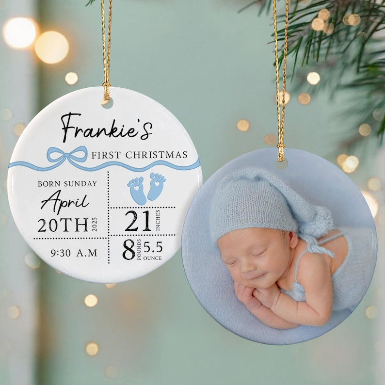 Two round ceramic ornaments with gold hanging strings. One features text Frankie's First Christmas, birth details including April 20th 2025, 21 inches, 8 pounds 5.5 ounces, and blue baby footprints.
