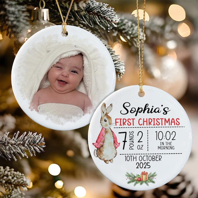 Two round white ceramic ornaments with gold hanging strings. One features a photograph of a smiling baby in a hooded towel.
