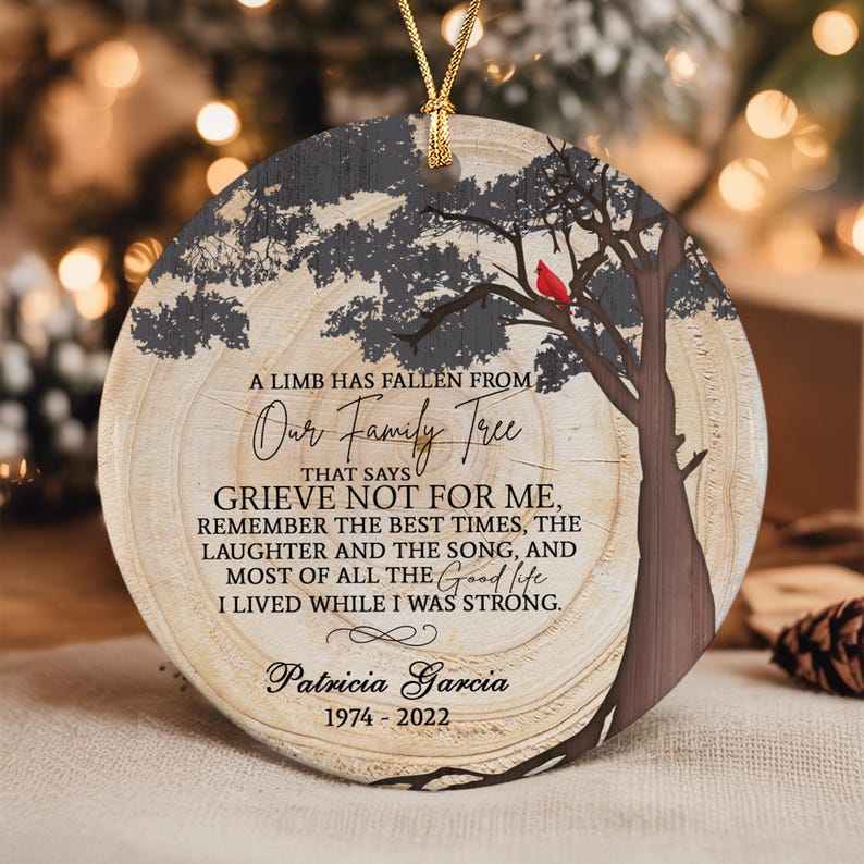 A round ceramic ornament featuring a wood grain background with a dark tree silhouette and a red cardinal.