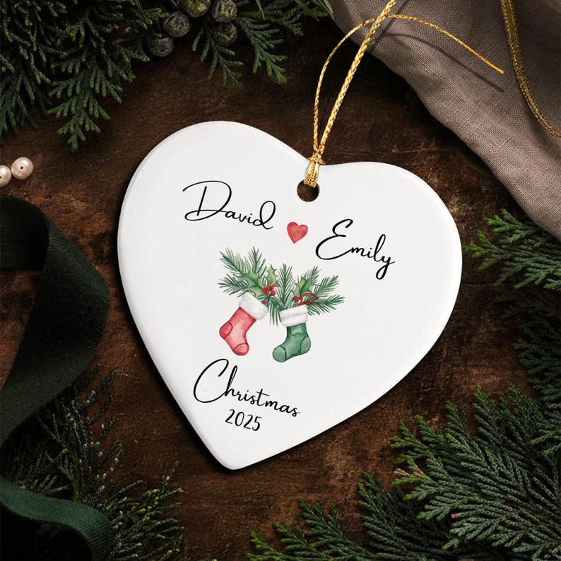 A white heart-shaped ceramic ornament featuring a gold hanging string.