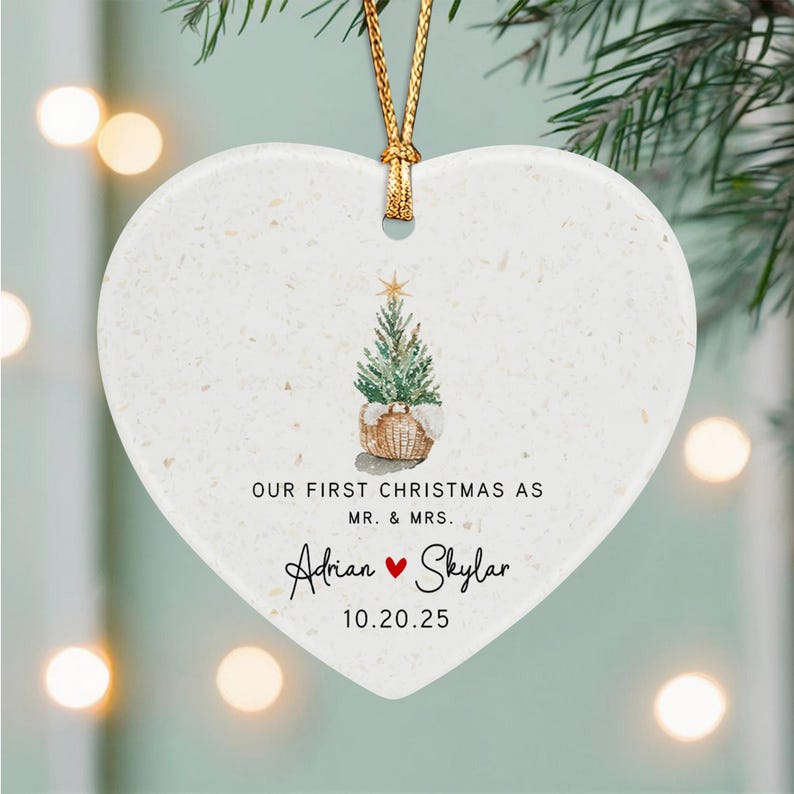 A white heart-shaped ceramic ornament with a gold hanging cord.