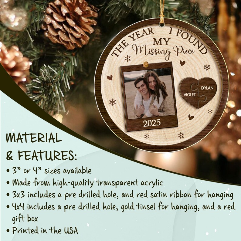 A round wooden-look ornament featuring the text THE YEAR I FOUND MY Missing Piece and 2025. It includes a square photo frame with a couple, a heart-shaped puzzle piece with the names VIOLET and DYLAN, and snowflake accents.