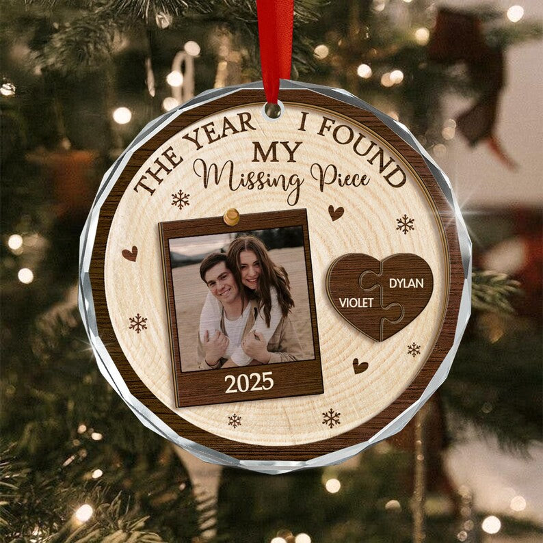 A round, wood-grain patterned Christmas ornament with a red ribbon hanger.