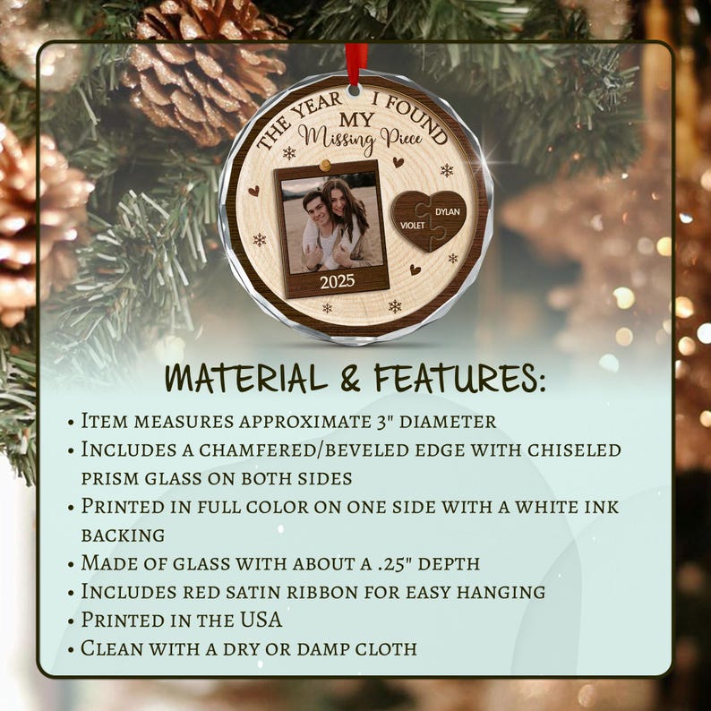 A round glass ornament with a wood grain print, featuring the text THE YEAR I FOUND MY MISSING PIECE, a photo of a couple, a heart-shaped puzzle piece with the names VIOLET and DYLAN, the year 2025, and a red satin ribbon.