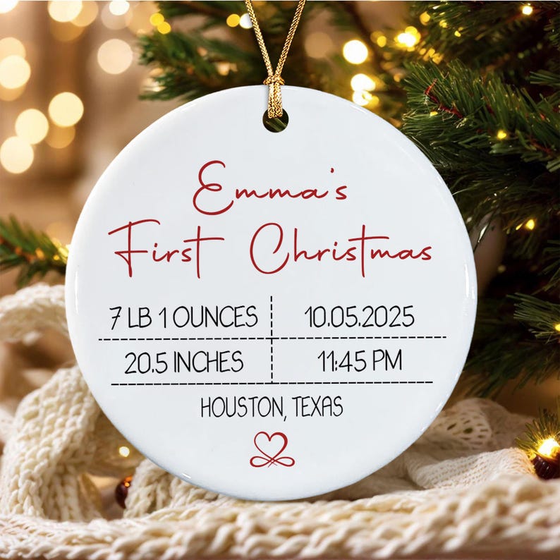 A round white ceramic Christmas ornament with a gold hanging cord.