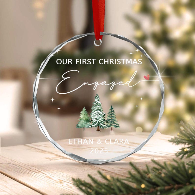 A circular clear acrylic ornament with faceted edges, hanging from a red ribbon.