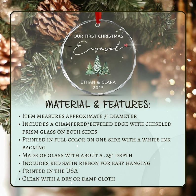 A circular glass ornament with a beveled edge, featuring the text OUR FIRST CHRISTMAS Engaged, a small red heart, a graphic of three pine trees, and the names ETHAN & CLARA with the year 2025.