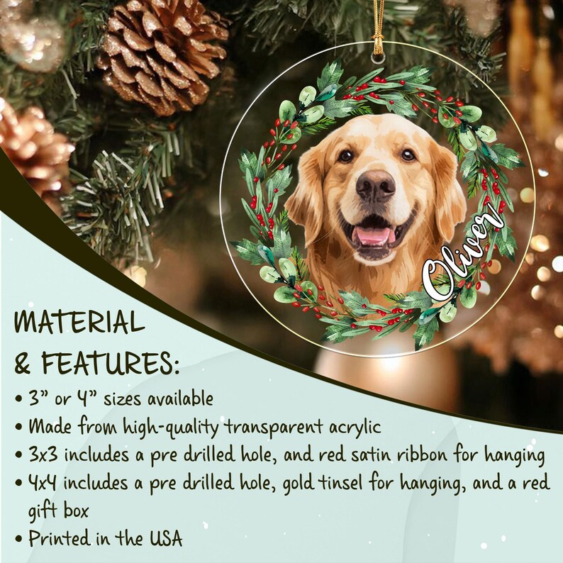 A circular transparent acrylic ornament featuring a portrait of a golden retriever dog surrounded by a green wreath with red berries. The name Oliver is printed in white script on the right side. It includes a gold hanging cord.
