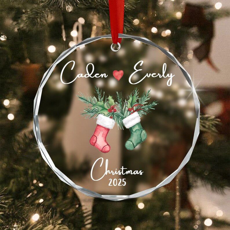 A round, faceted glass Christmas ornament hanging from a red ribbon.