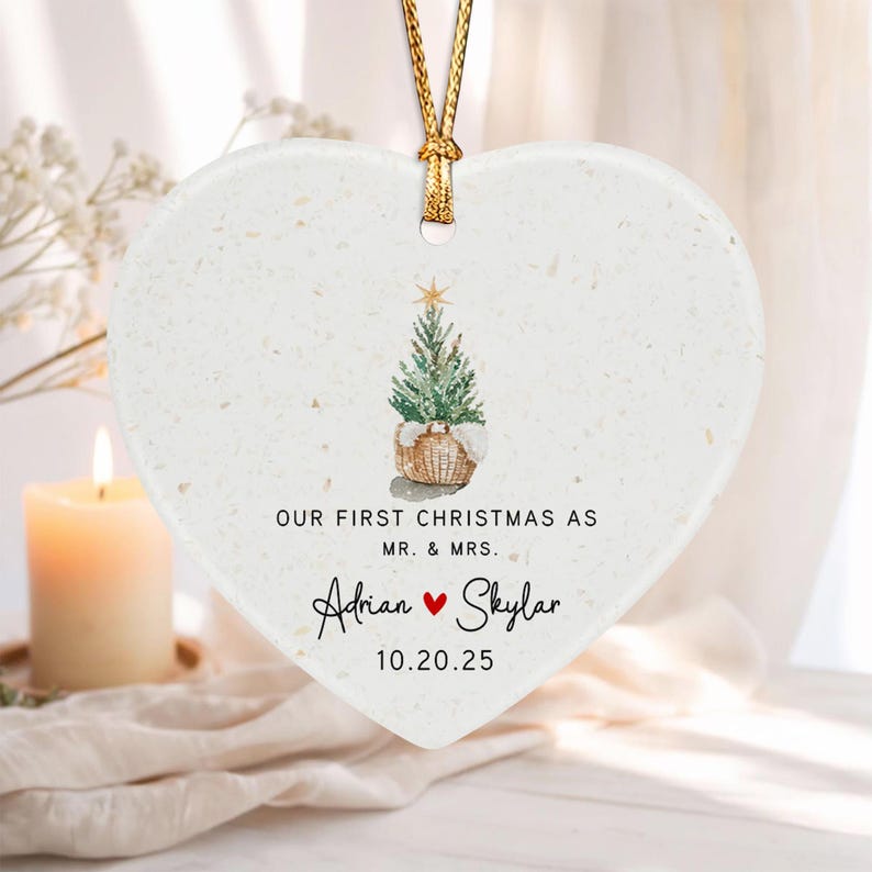 A white heart-shaped ceramic ornament with a gold hanging cord.