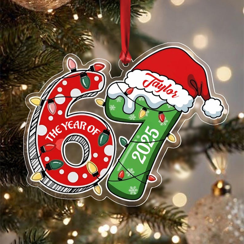 A flat, die-cut Christmas ornament shaped like the number 67. The red number 6 features white polka dots and the text THE YEAR OF. The green number 7 is topped with a red Santa hat bearing the name Taylor and the year 2025.