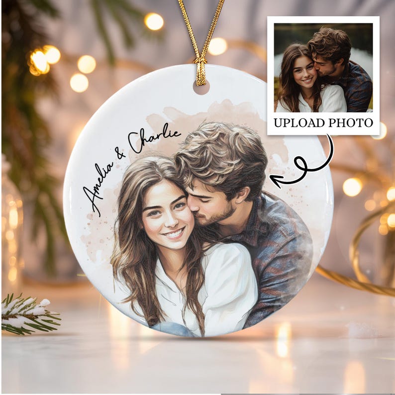 A round white ceramic ornament featuring a watercolor-style illustration of a couple embracing, with the names Amelia & Charlie printed in black script.