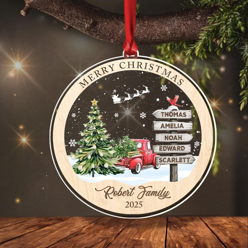 A round wooden Christmas ornament hanging by a red ribbon.