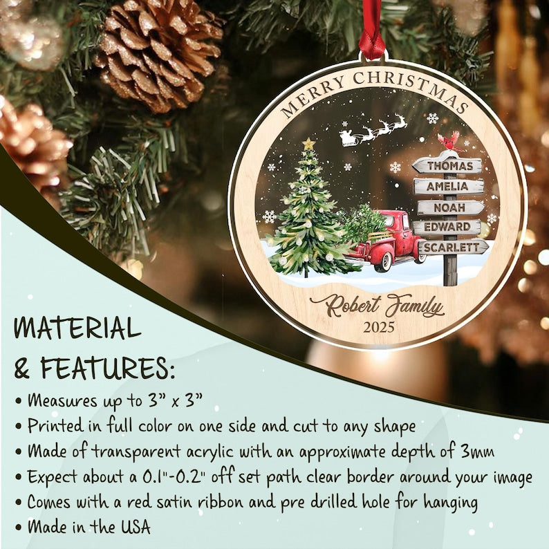 A round transparent acrylic Christmas ornament featuring a printed scene of a red truck, a decorated pine tree, and a signpost with five names. The text reads Merry Christmas, Robert Family, and 2025.