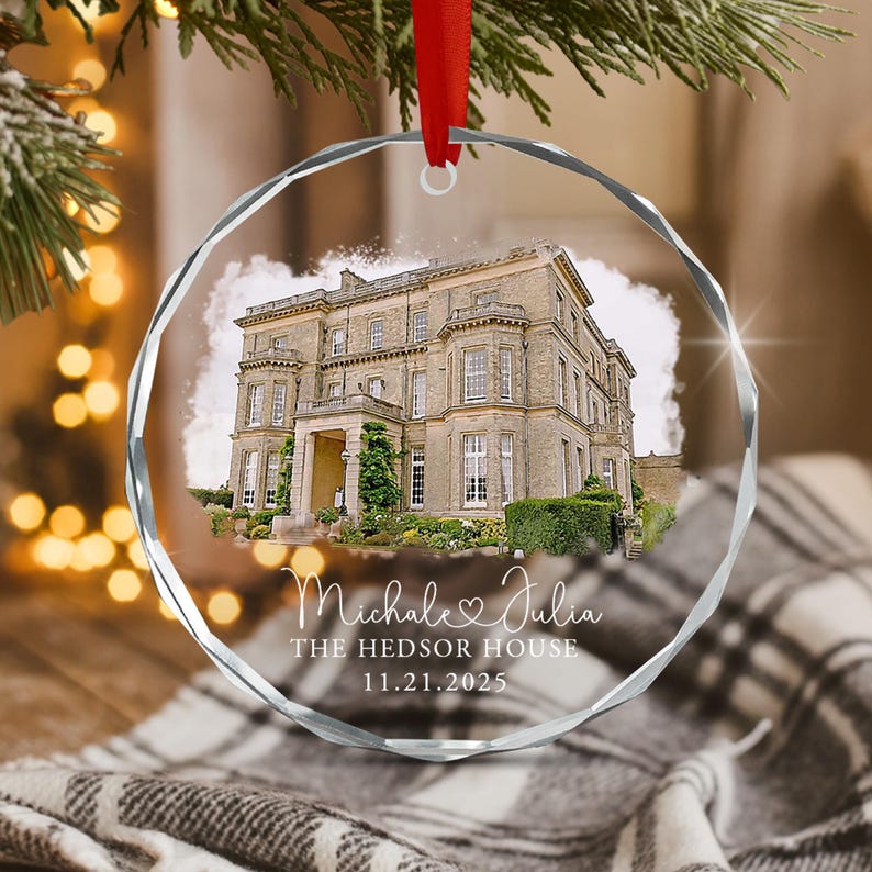 A circular, faceted glass ornament featuring a printed image of a large stone mansion. Below the house, white text reads "Michale & Julia", "THE HEDSOR HOUSE", and "11.21.2025".