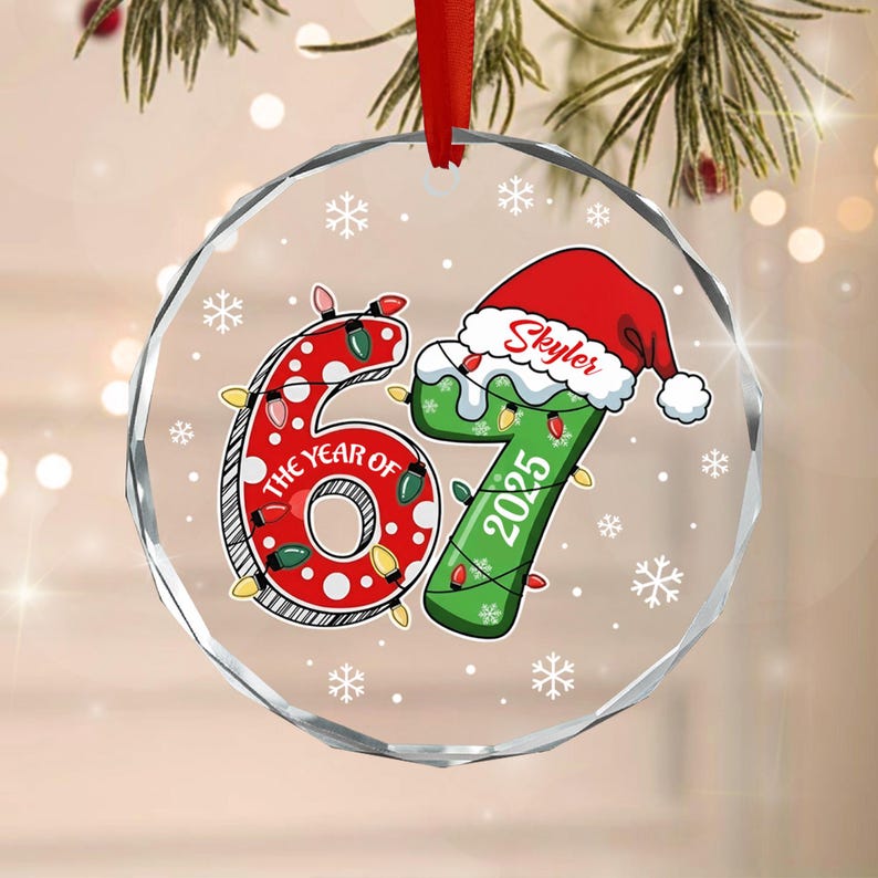 A round, clear, faceted glass ornament featuring a red number 6 with white polka dots and the text THE YEAR OF, paired with a green number 7 wearing a Santa hat with the name Skyler and the year 2025.