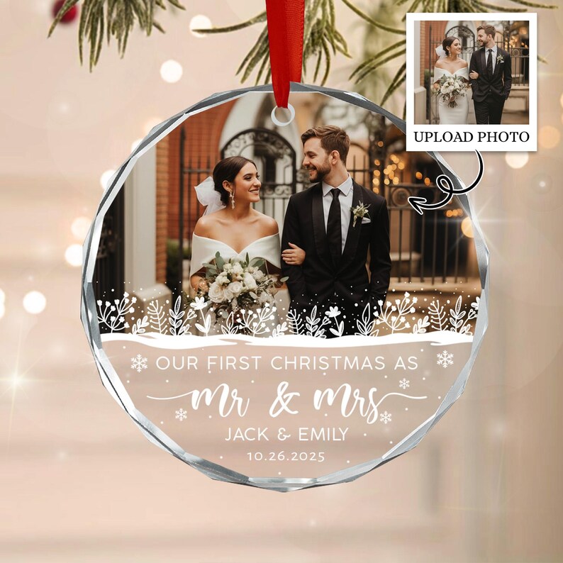 A round, faceted glass Christmas ornament featuring a printed wedding photograph of a couple.