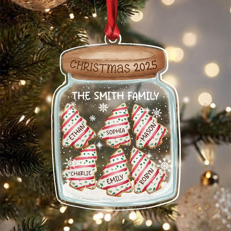 A clear jar-shaped Christmas ornament featuring a brown lid with the text CHRISTMAS 2025. Inside the jar, the text THE SMITH FAMILY appears above six tree-shaped cookies with red and green stripes, each labeled with names.