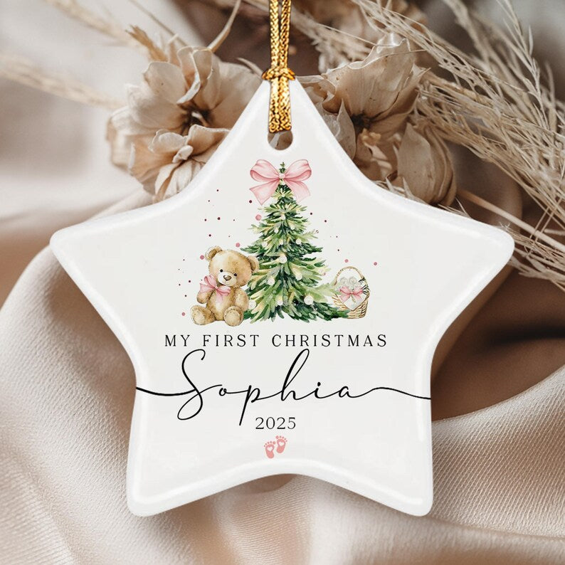 A white star-shaped ceramic ornament featuring a watercolor illustration of a teddy bear, a Christmas tree with a pink bow, and a basket.