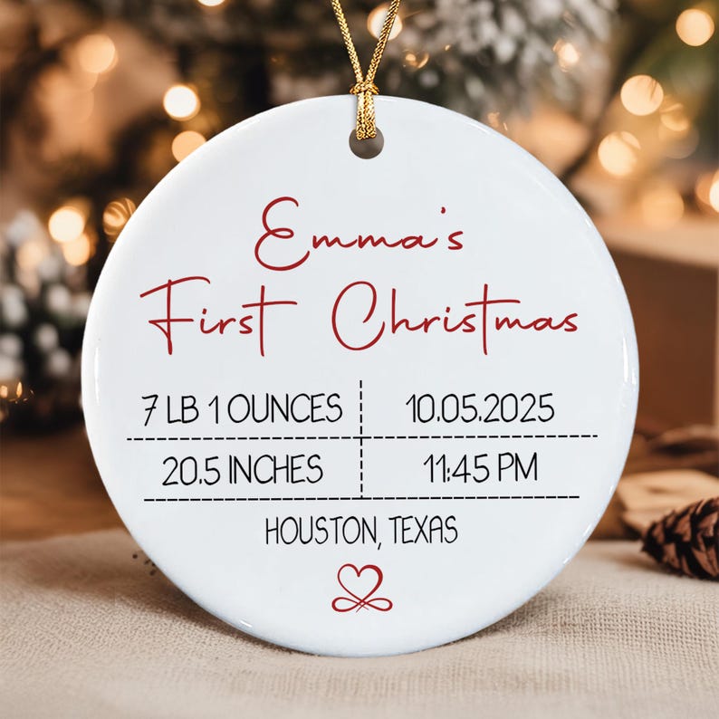 A round white ceramic ornament with a gold hanging cord.