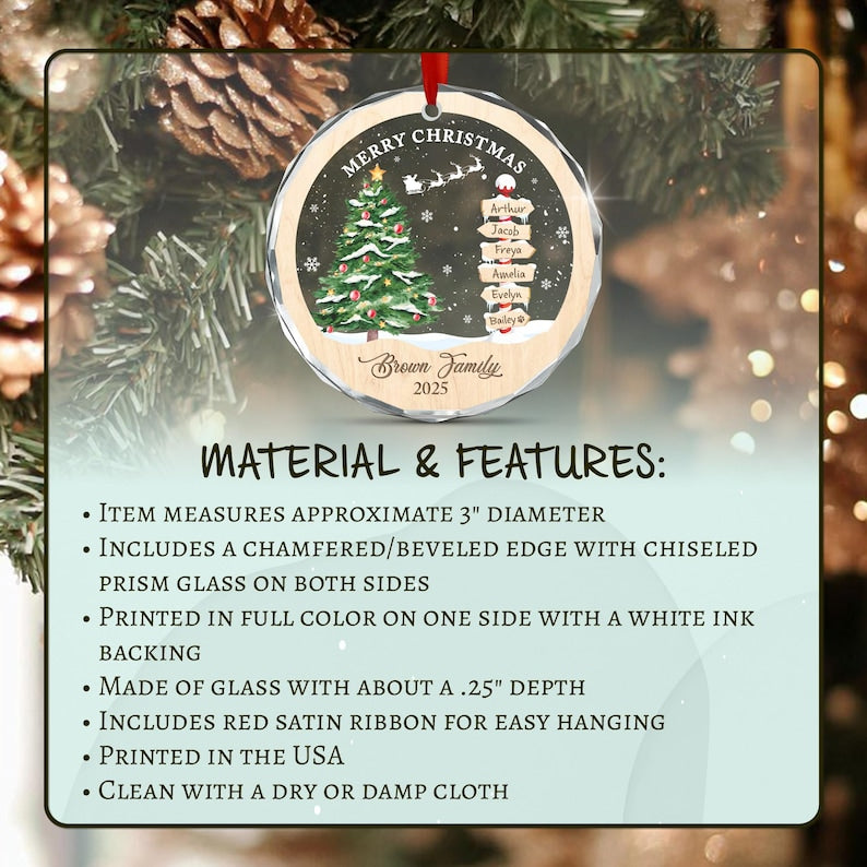 A round glass Christmas ornament with a 3-inch diameter and 0.25-inch depth. It features a printed design of a decorated tree, a signpost with names, and the text Merry Christmas, Brown Family, and 2025. It has a red satin ribbon.