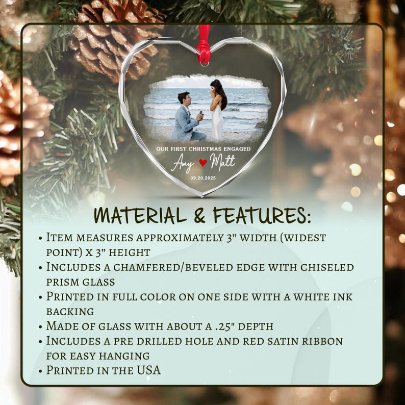 A heart-shaped glass ornament with a beveled edge and chiseled prism design. It features a printed photograph of a couple on a beach, with the text OUR FIRST CHRISTMAS ENGAGED, Amy and Matt, and the date 09.20.2025.