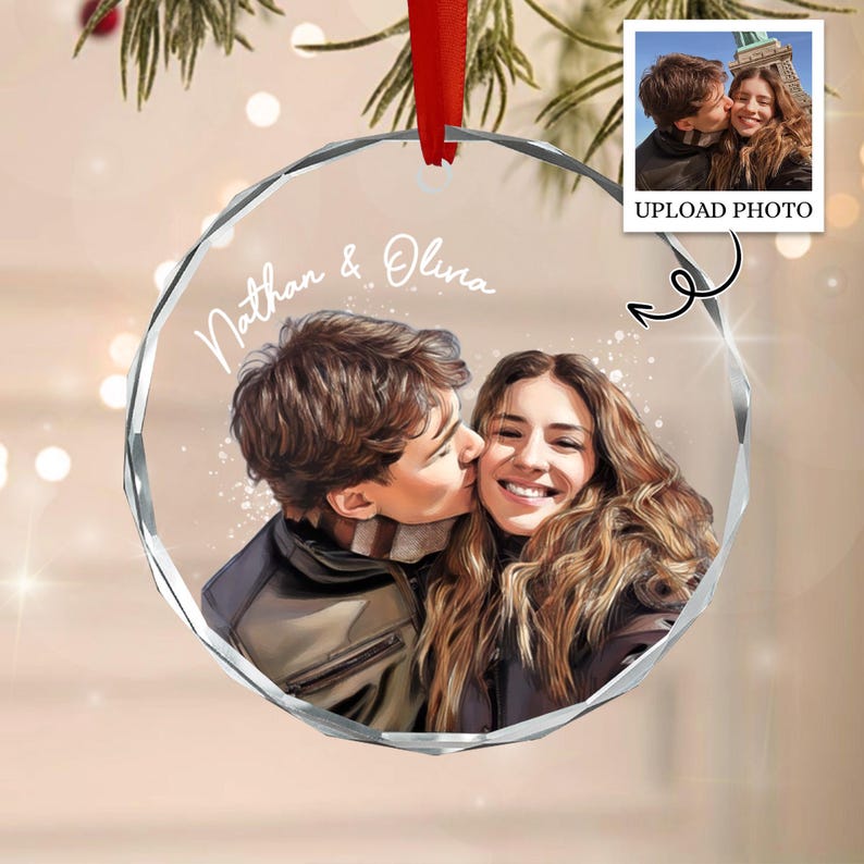 A circular clear acrylic ornament featuring a custom illustration of a couple with the text Nathan & Olina printed in white. The ornament has faceted edges and hangs from a red ribbon, displaying a portrait of two people.