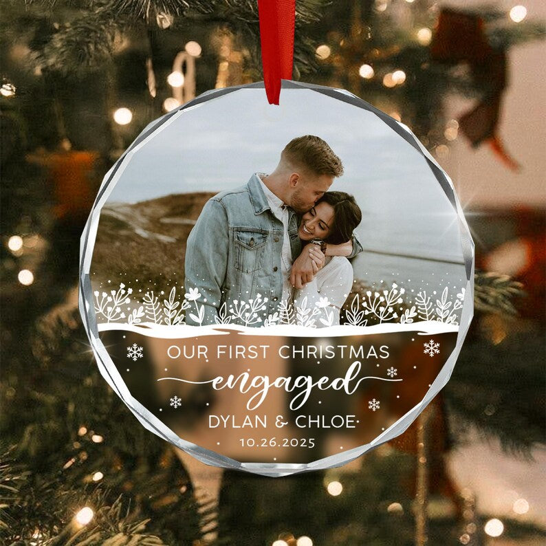 A round, clear glass Christmas ornament featuring a photo of a couple embracing.