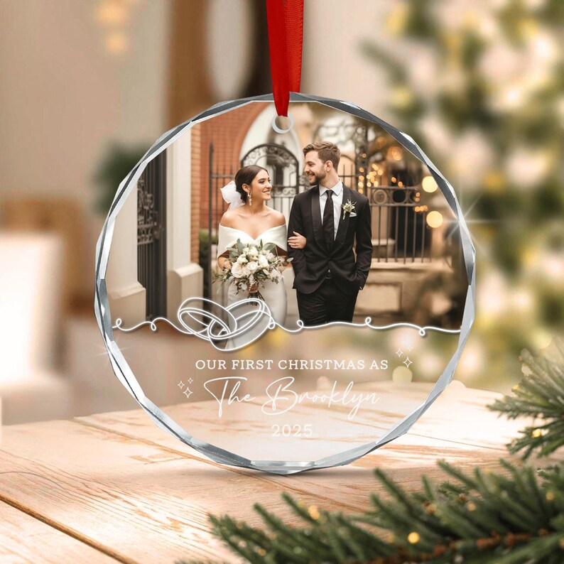 A circular clear acrylic ornament featuring a printed photograph of a couple in wedding attire.