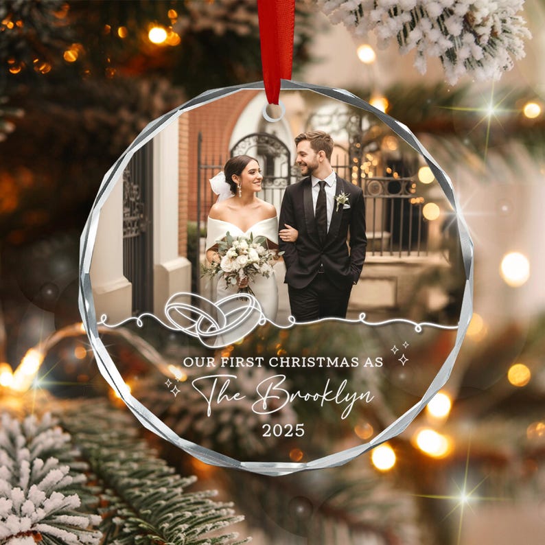 A circular, faceted glass Christmas ornament featuring a printed wedding photograph of a couple.