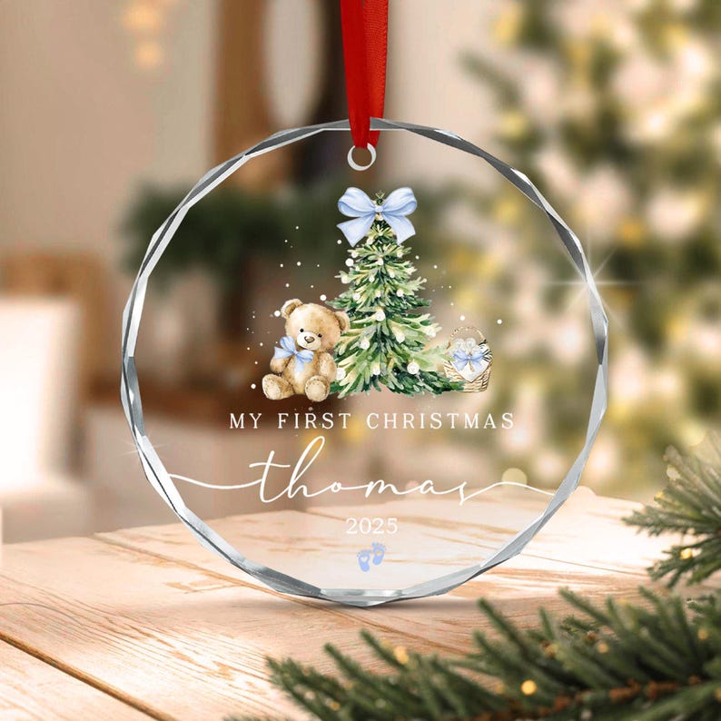 A circular clear acrylic ornament hanging from a red ribbon.