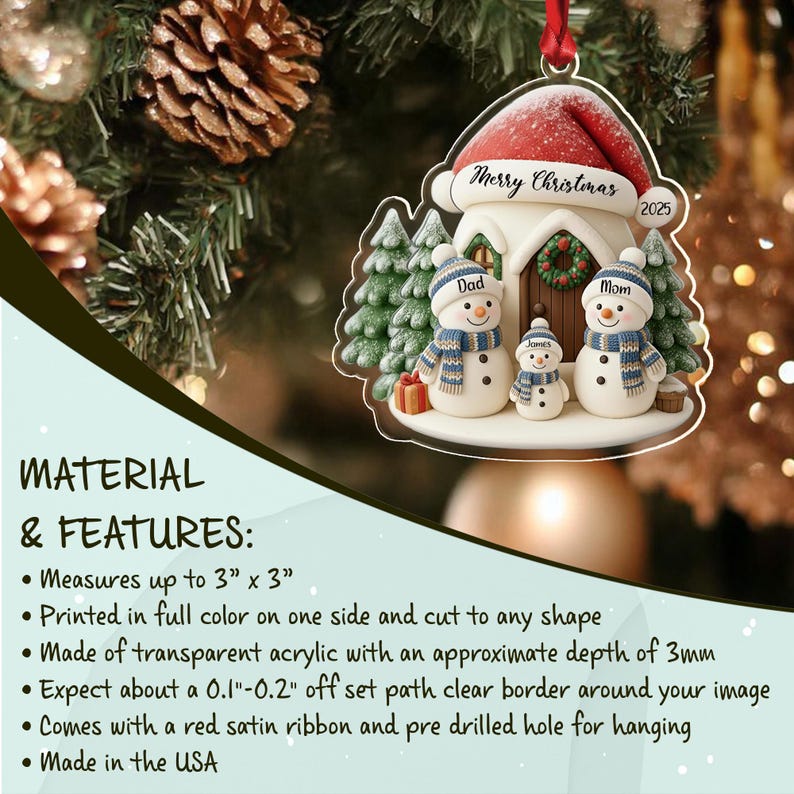 A transparent acrylic Christmas ornament featuring a house with a red Santa hat roof, three snowmen labeled Dad, Mom, and James, and green pine trees.