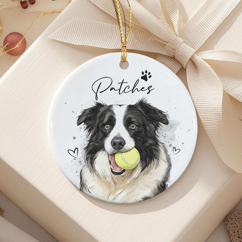 A round white ceramic ornament featuring a black and white Border Collie illustration holding a yellow tennis ball in its mouth.