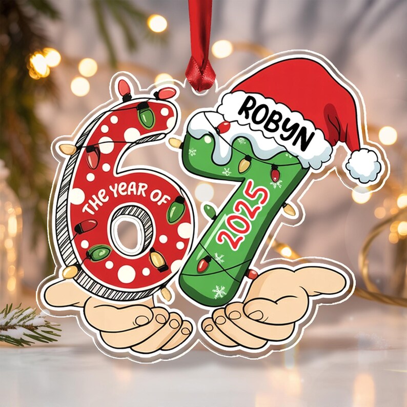 A flat, hanging Christmas ornament shaped like the number 67. The red 6 is decorated with white dots and string lights, featuring the text THE YEAR OF.