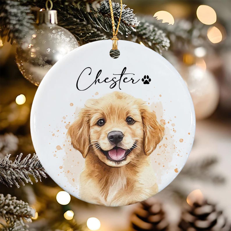 A round white ceramic ornament featuring a watercolor-style illustration of a golden retriever puppy. The name Chester is printed in black script above the puppy, accompanied by a small black paw print icon.