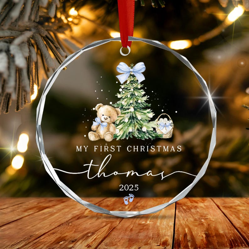 A round, faceted glass Christmas ornament hanging from a red ribbon.