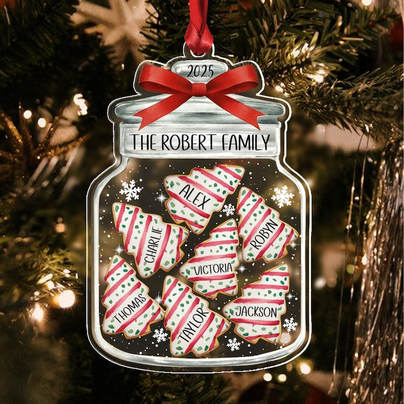 A flat, jar-shaped Christmas ornament featuring a red ribbon at the top with the year 2025. The jar is labeled The Robert Family and contains seven tree-shaped cookies with red and green stripes, each personalized with names.