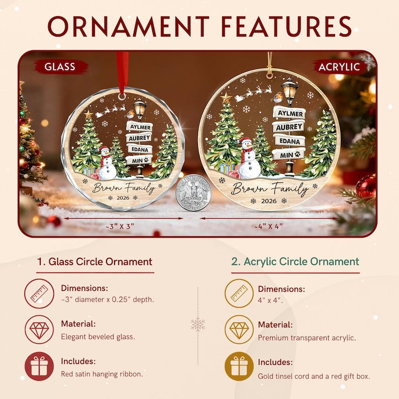 Two circular Christmas ornaments, one glass and one acrylic, featuring a printed winter scene with a snowman, pine trees, a street lamp with signs reading Aylmer, Aubrey, Edana, Min, and the text Brown Family 2026.