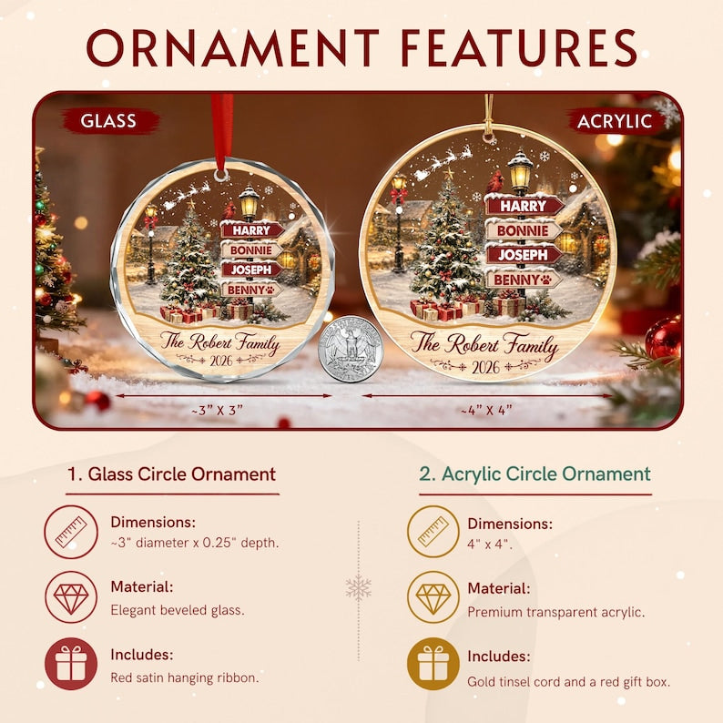 Two round Christmas ornaments, one glass and one acrylic, featuring a snowy village scene with a Christmas tree, streetlamp, and a signpost with the names Harry, Bonnie, Joseph, and Benny. Text reads The Robert Family 2026.