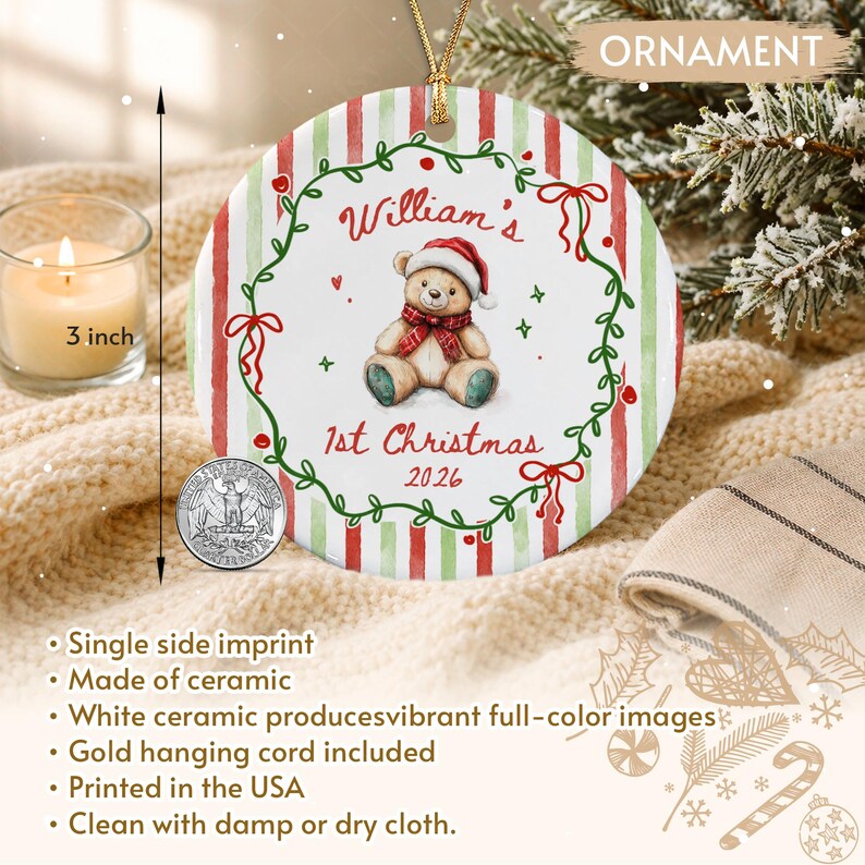 A round white ceramic Christmas ornament featuring a red and green striped border and a central illustration of a teddy bear wearing a Santa hat and scarf. The text reads William's 1st Christmas 2026.
