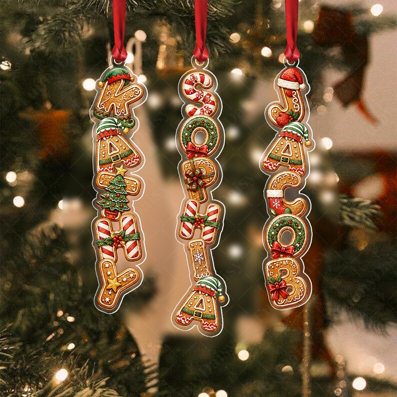Three vertical Christmas ornaments hanging by red ribbons.