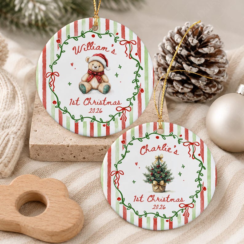 Two round ceramic Christmas ornaments featuring red and green vertical stripes. One ornament displays a teddy bear in a Santa hat with the text 'William's 1st Christmas 2026'.
