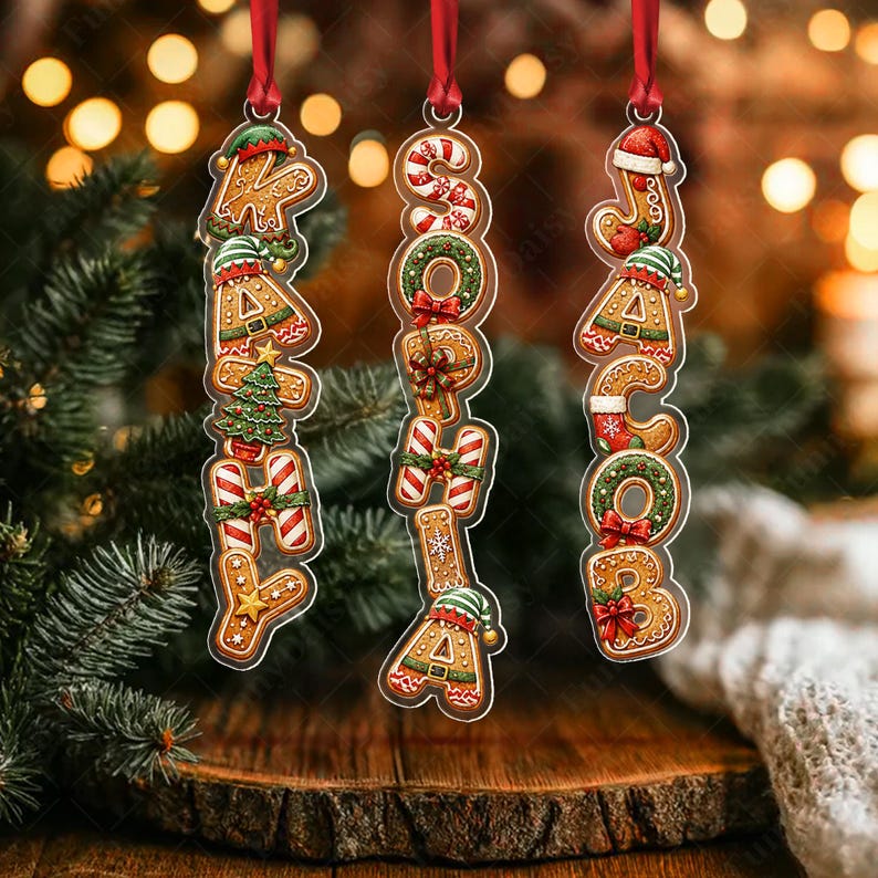 Three vertical Christmas ornaments hanging by red ribbons, each featuring gingerbread-style letters spelling the names KATHY, SOPHIA, and JACOB. The letters are decorated with candy canes, green wreaths, red bows, and elf hats.
