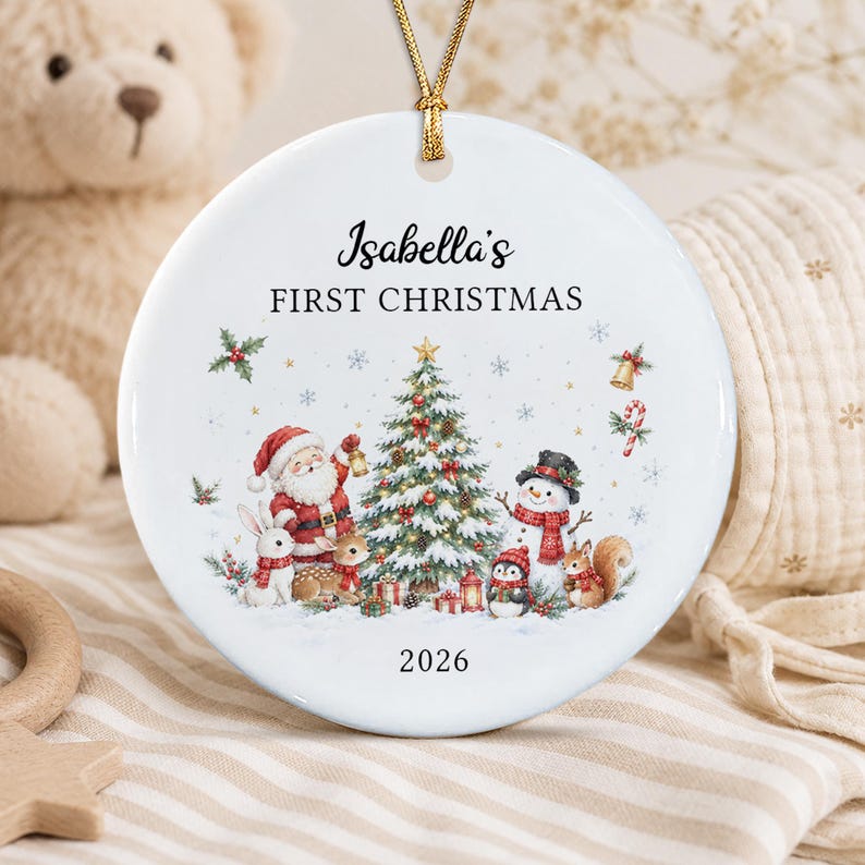 A round white ceramic Christmas ornament featuring a gold hanging cord.